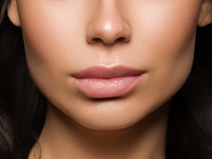 Close up of a woman's full, pouty mouth after getting cosmetic lip treatments like Botox lip flip.