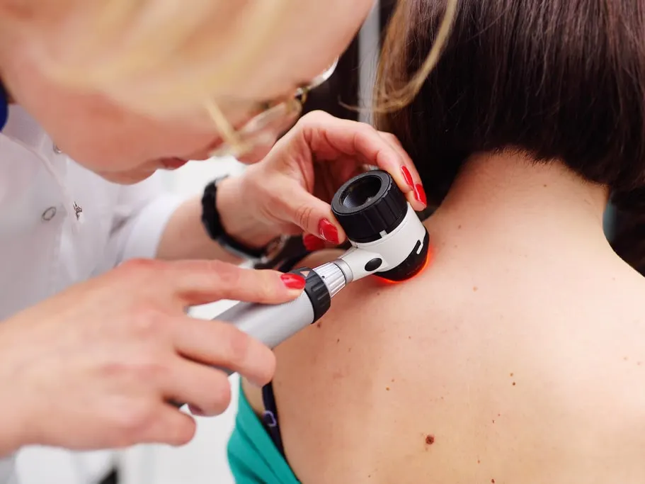 Patient having her skin examined by a dermatologist during a skin cancer screening.