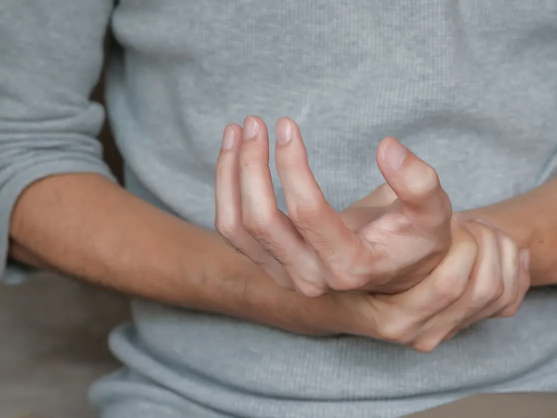 Man experiencing hand weakness related to lupus.