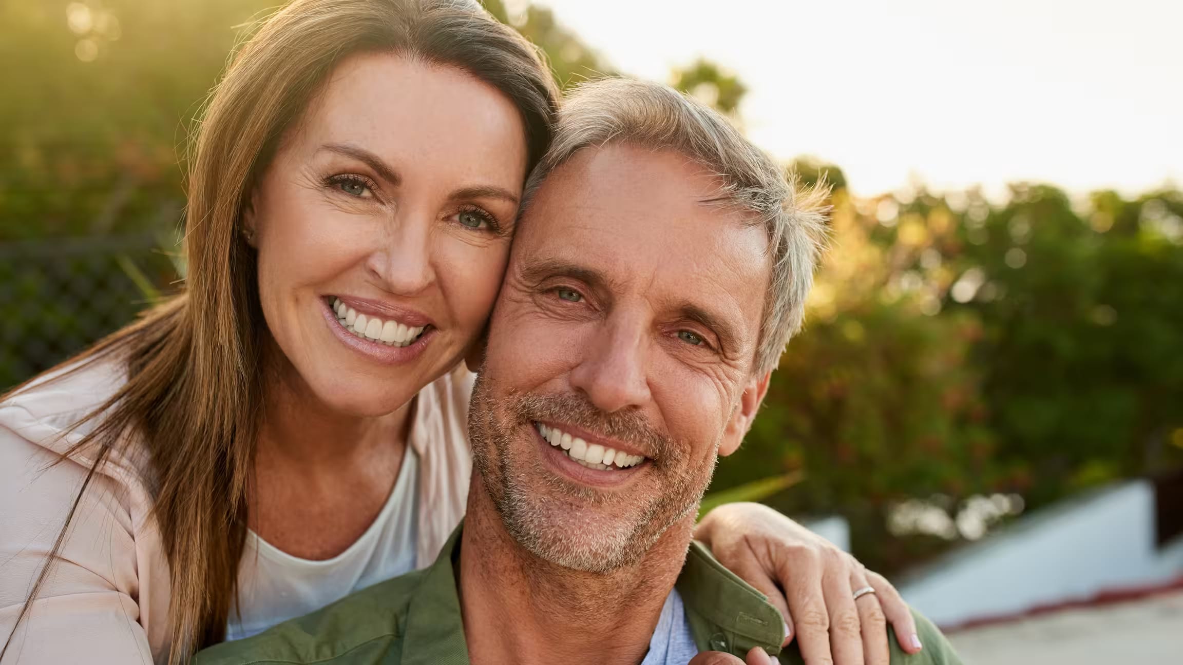 A smiling couple outdoors in the evening sun (models)