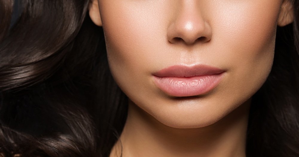 Close up of a woman's full, pouty mouth after getting cosmetic lip treatments like Botox lip flip.