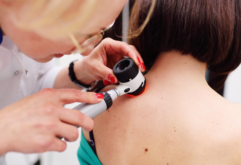 Patient having her skin examined by a dermatologist during a skin cancer screening.